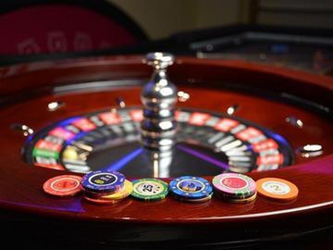 Dealers di meja roulette dalam studio live casino dengan nasabah yang aktif